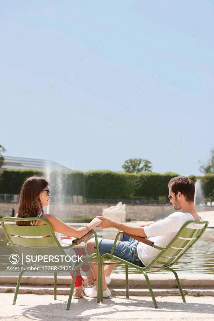 Couple sitting in chairs near a pond, Bassin octogonal, Jardin des Tuileries, Paris, Ile_de_France, France