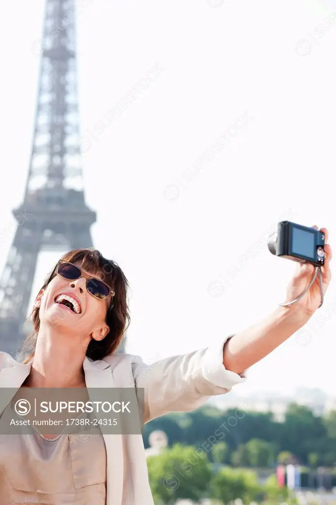 Woman taking a picture of herself with the Eiffel Tower in the background, Paris, Ile_de_France, France