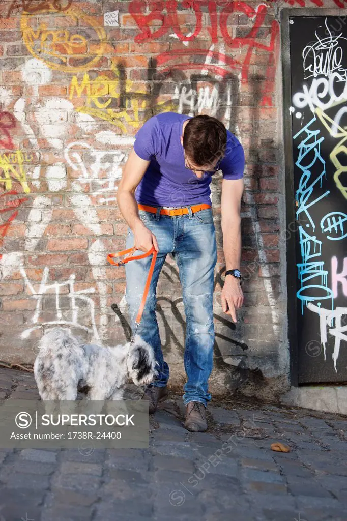 Man showing feces to his puppy, Paris, Ile_de_France, France