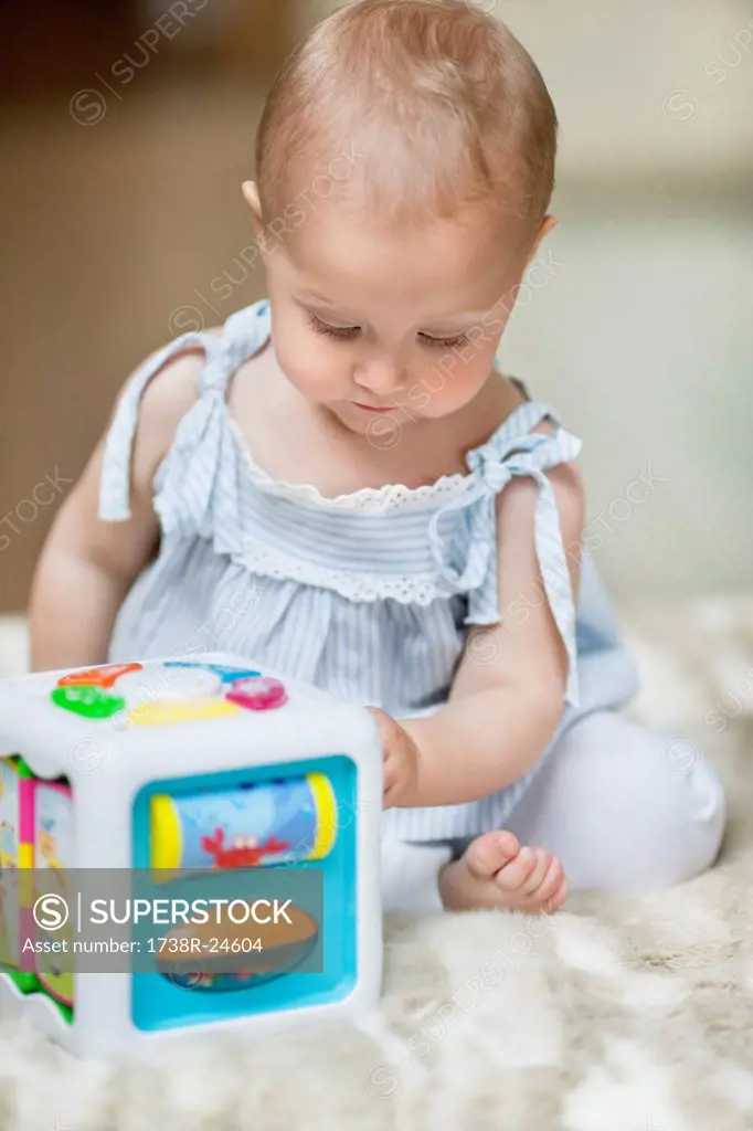 Baby girl playing with a musical block toy