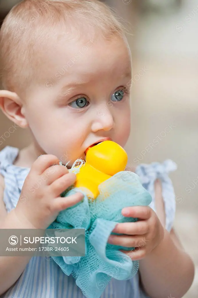 Close_up of a baby girl playing with a toy