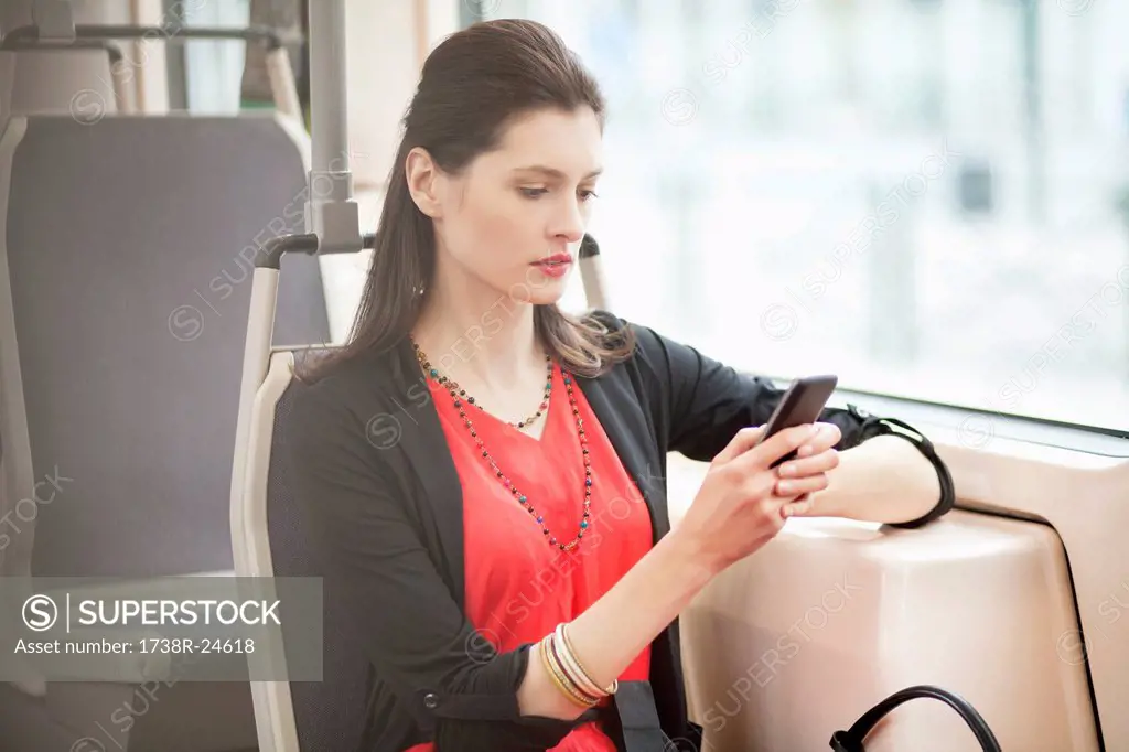 Woman traveling in a bus and using a mobile phone