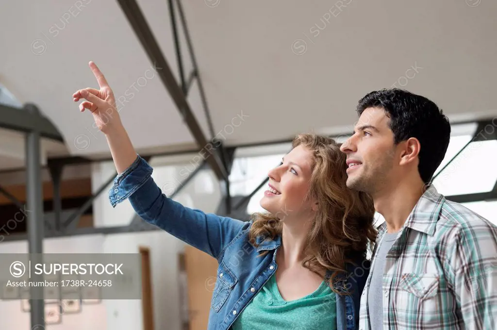 Happy woman pointing with her husband beside her