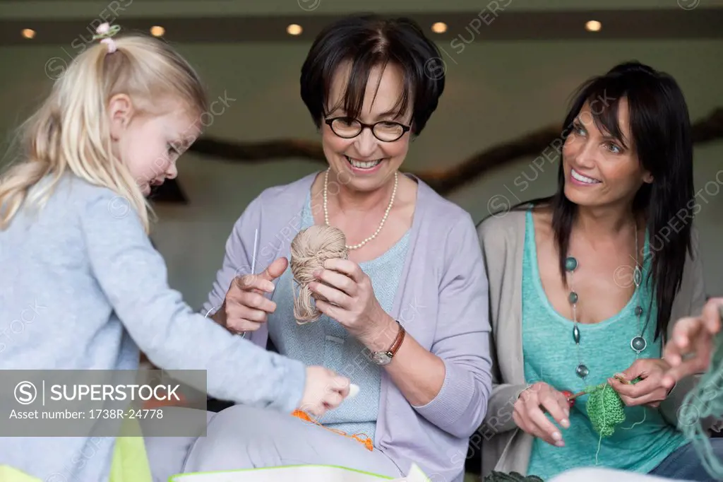 Girl learning knitting with her mother and grandmother