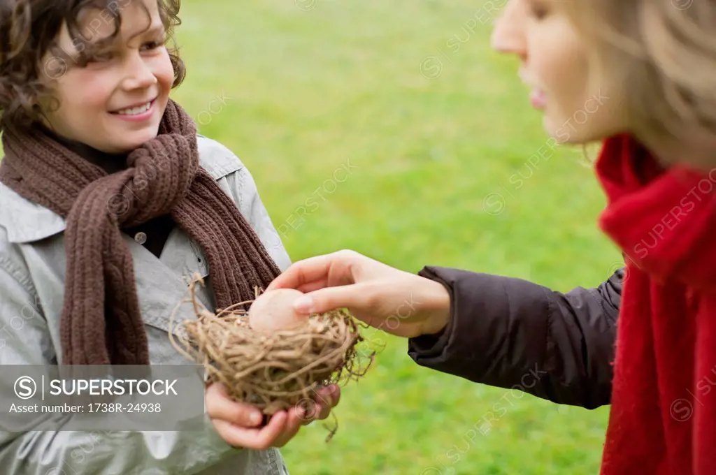 Boy showing a bird´s nest to his mother