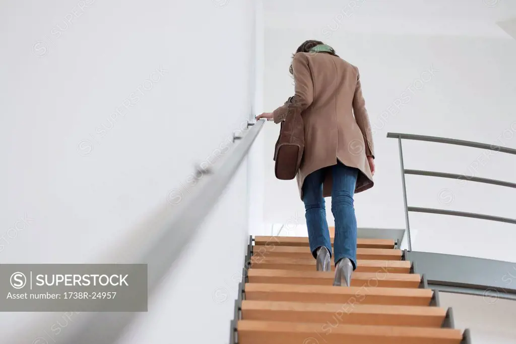Rear view of a woman moving up staircase