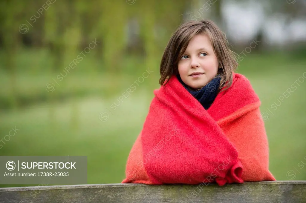 Girl wrapped in a blanket and thinking in a farm