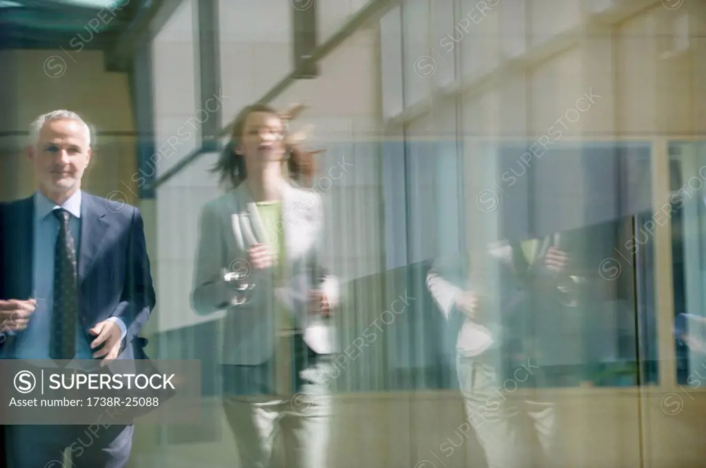 Two business executives running in the corridor