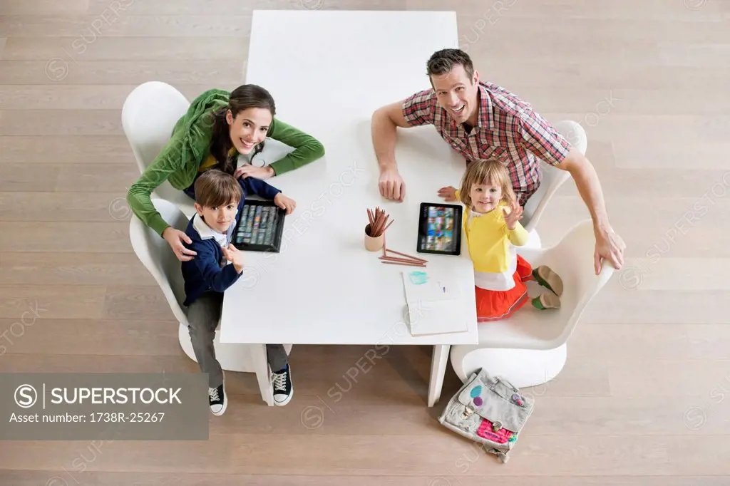 High angle view of couple with their children at study table