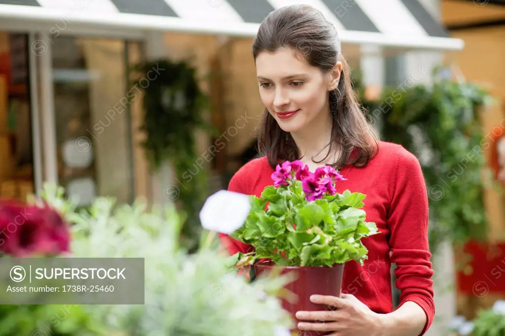 Woman holding a potted plant in a flower shop