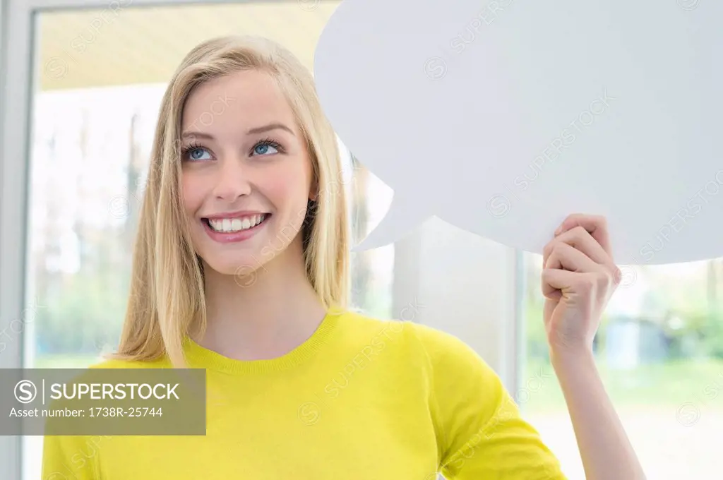 Woman holding a speech bubble and smiling