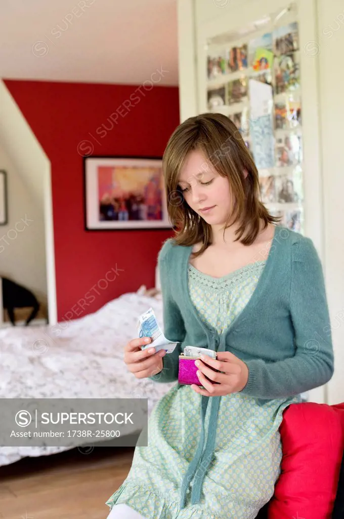 Girl holding pocket money in the bedroom