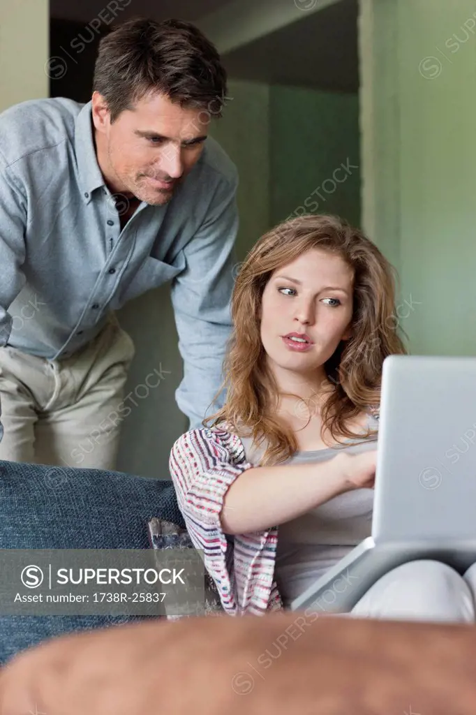 Couple using a laptop at home
