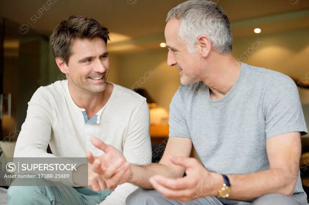 Two male friends discussing and smiling