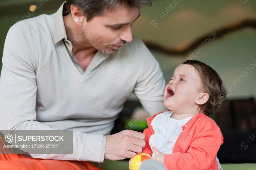 Man consoling his crying daughter