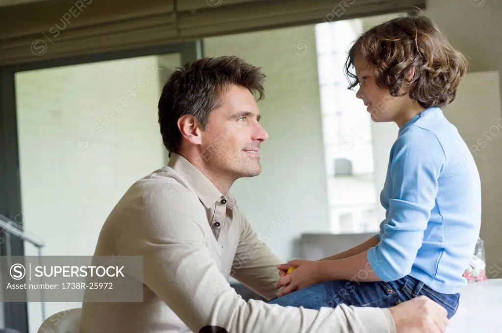 Man with his son looking at each other at home
