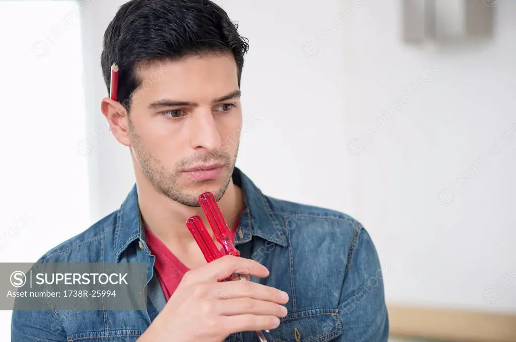 Technician holding screwdrivers and thinking
