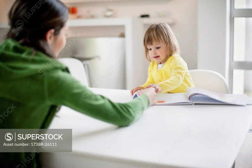 Woman teaching her daughter at home