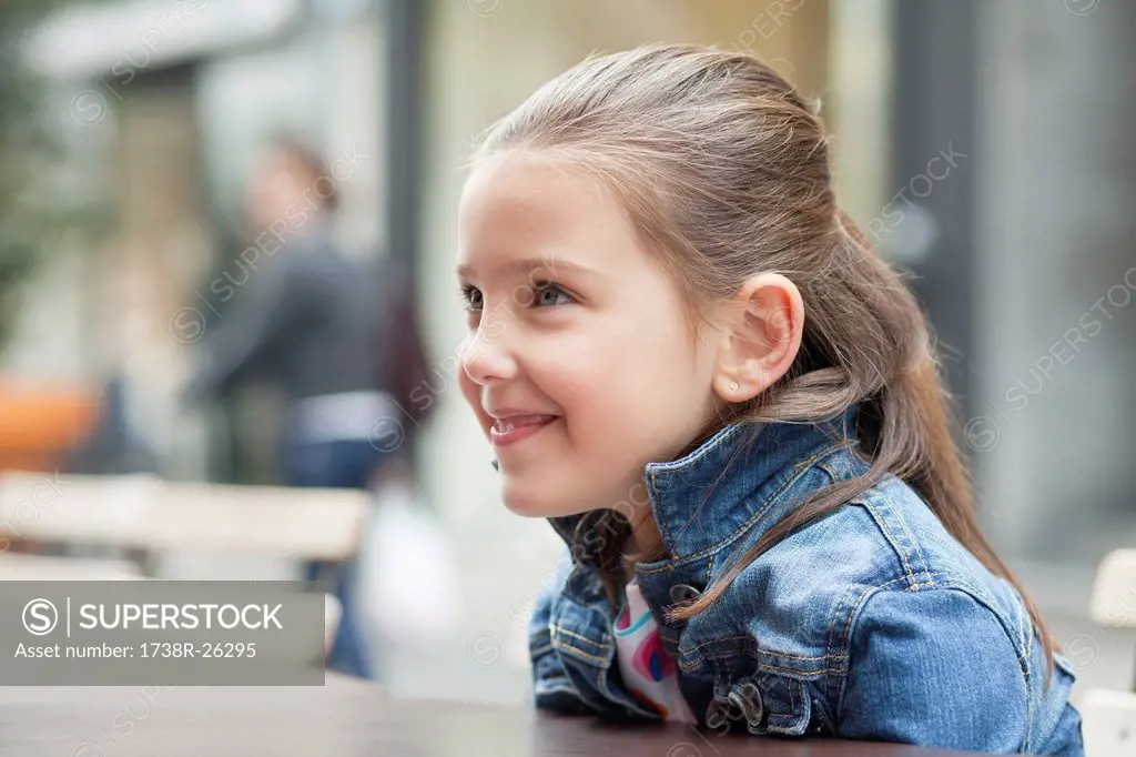 Close_up of a girl sitting at a sidewalk cafe
