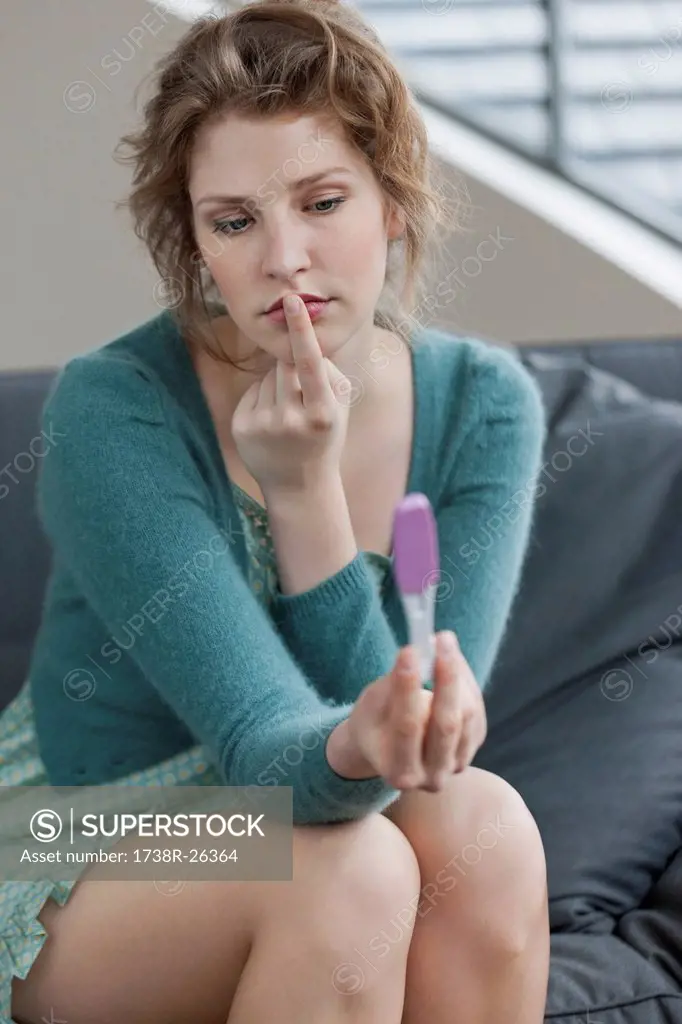 Woman looking sad after checking her pregnancy test