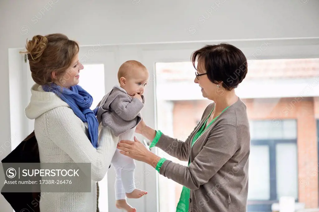 Woman giving her daughter to nanny