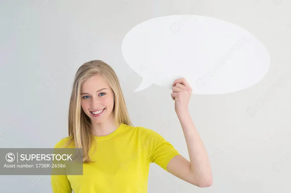 Woman holding a speech bubble and smiling
