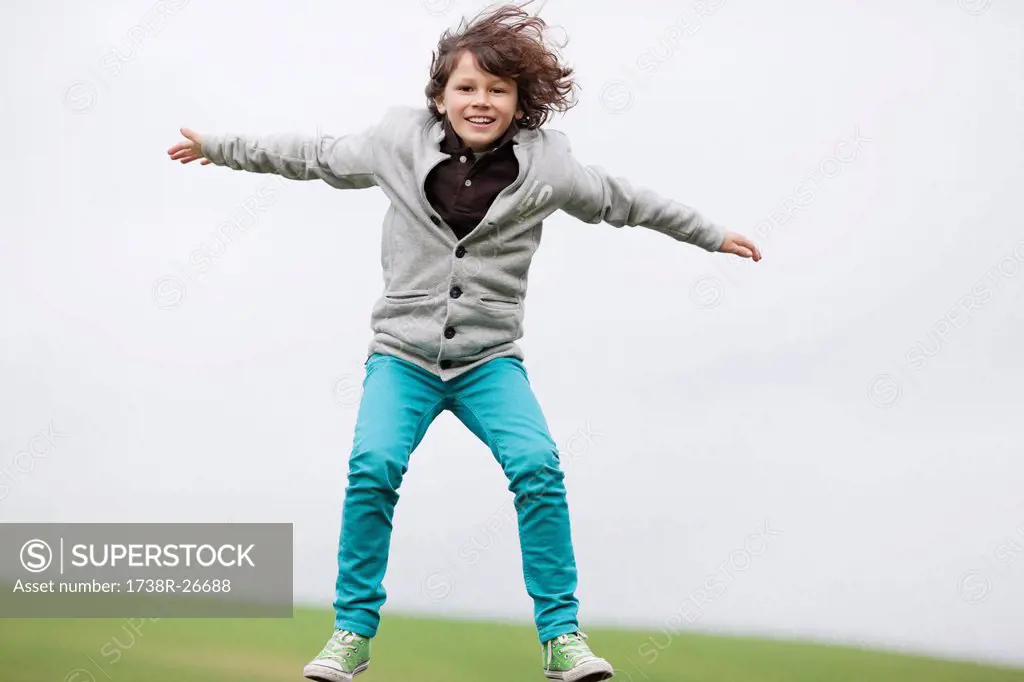 Portrait of a boy jumping in a field