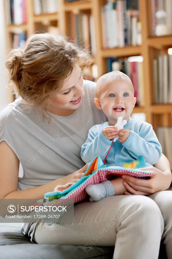 Woman reading a story to her baby from a picture book