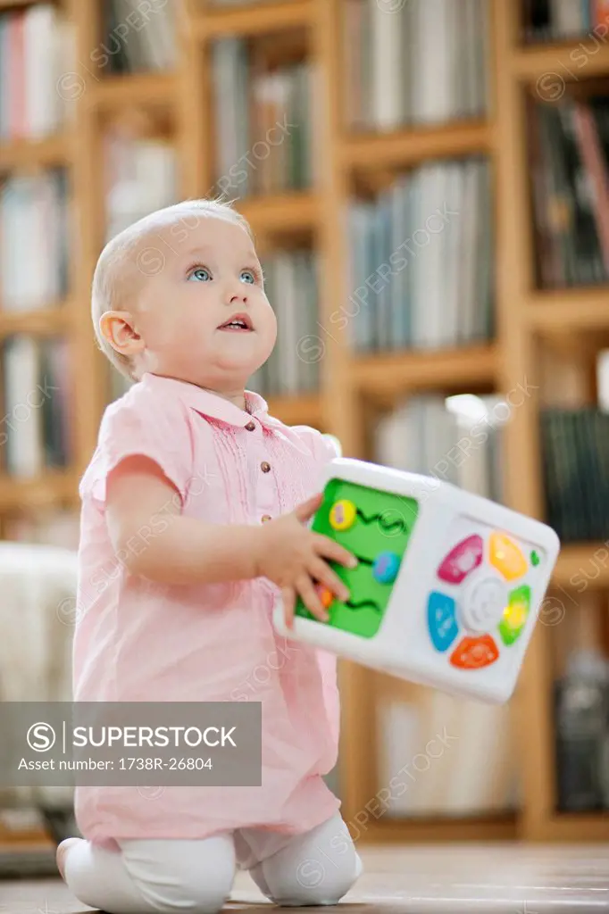 Baby girl playing with a musical block toy