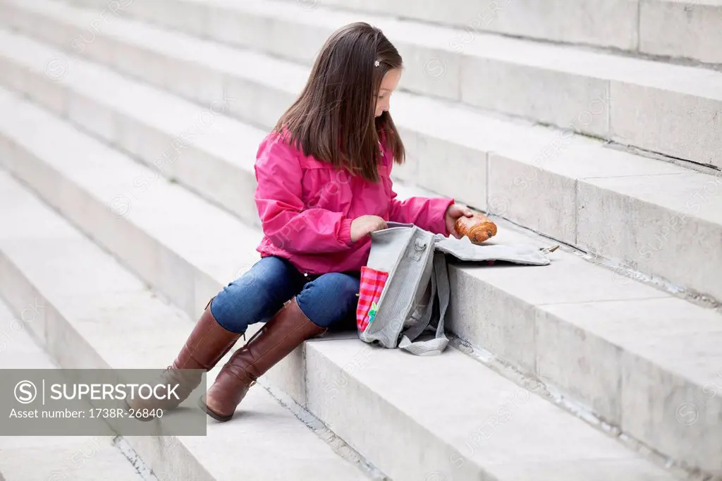 Girl taking out food from her schoolbag