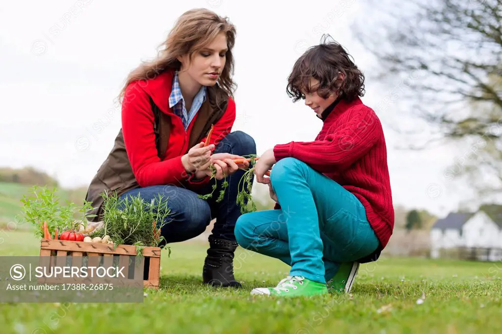 Woman and son looking at vegetables in a park