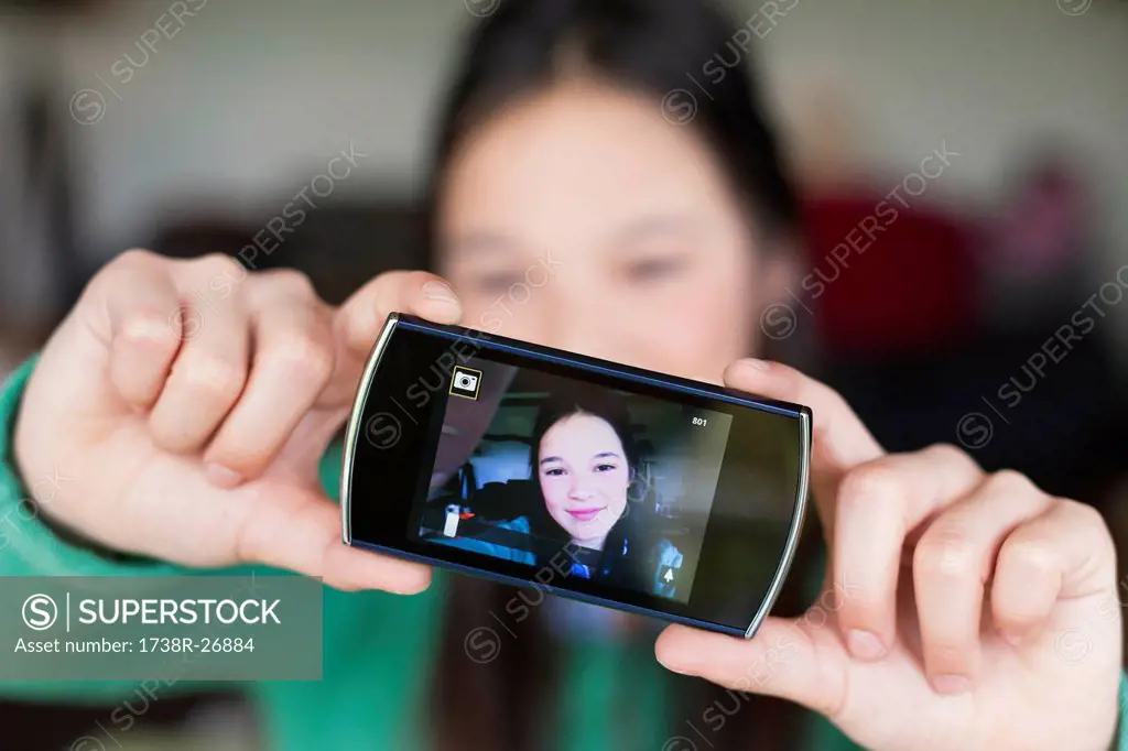 Girl taking picture of herself with a mobile phone