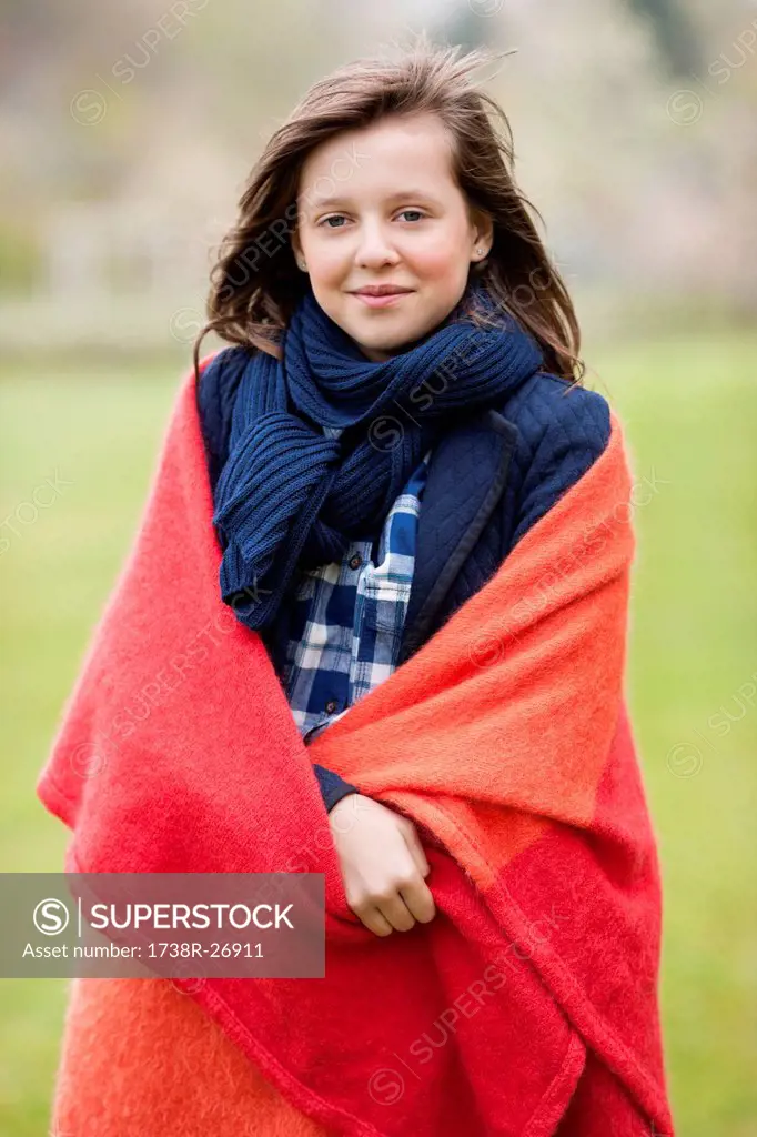 Portrait of a girl wrapped in a blanket and smiling