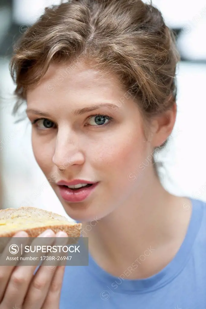 Portrait of a woman eating a bread