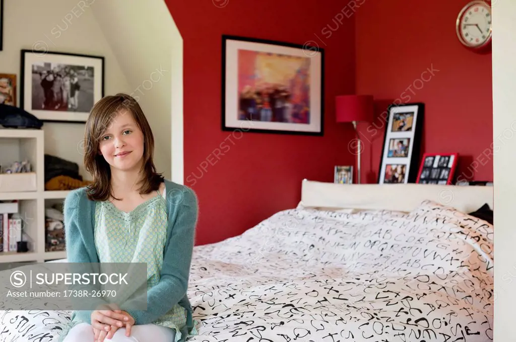 Portrait of a girl sitting on the bed and smiling