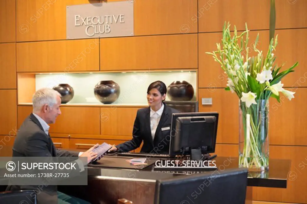 Businessman reading a brochure at a hotel reception counter