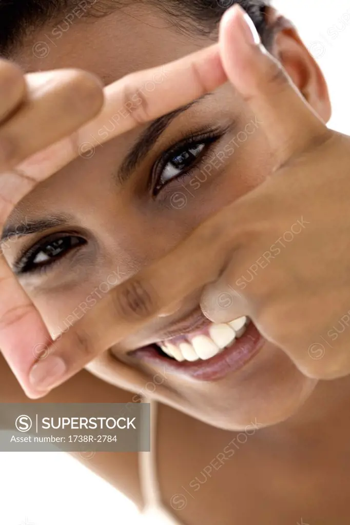 Portrait of a young smiling woman making a frame with her fingers