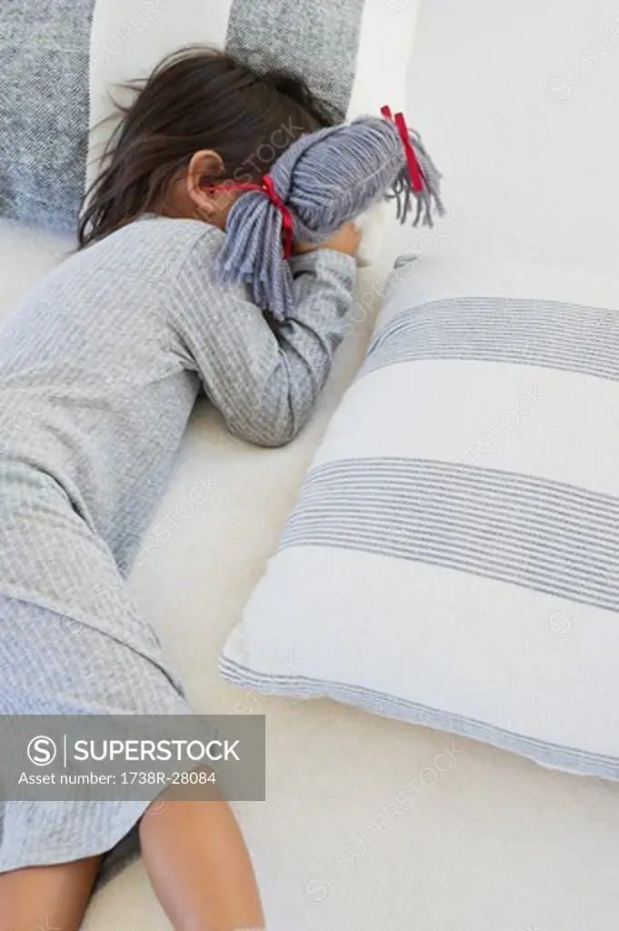 Girl sleeping on the bed with rag doll