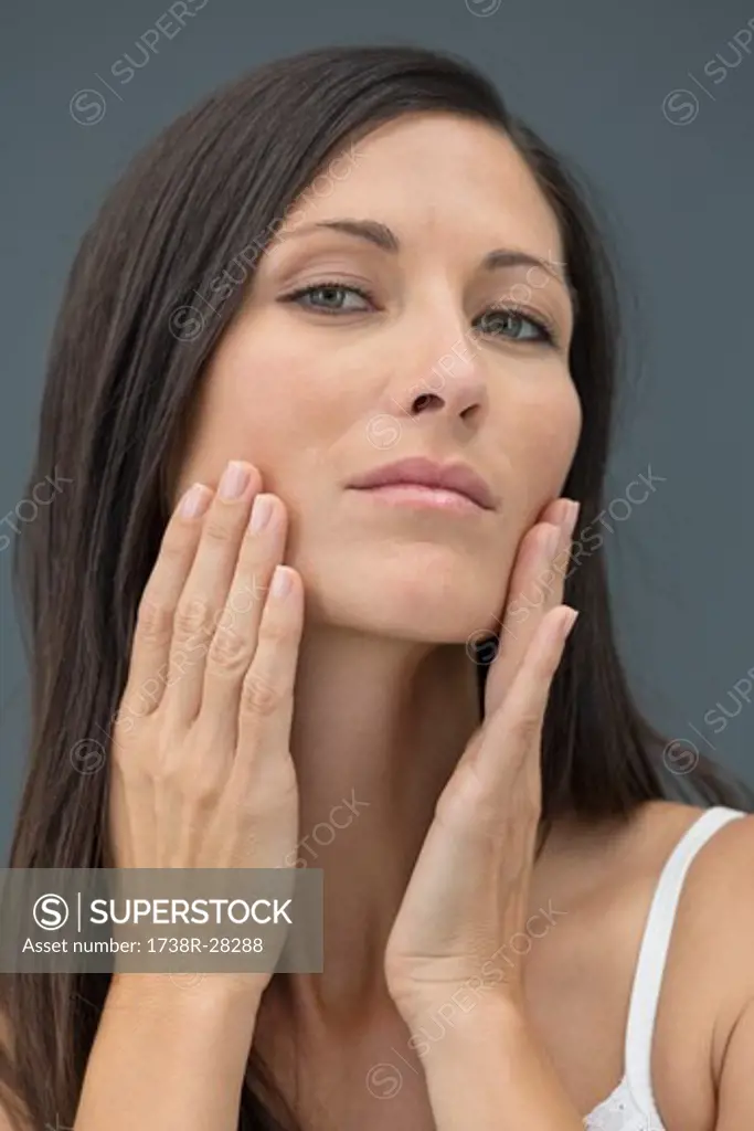 Portrait of a woman checking wrinkles on her face
