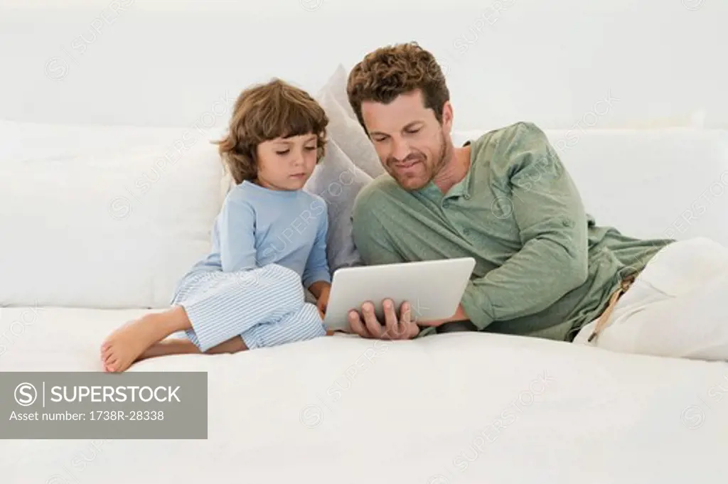 Man showing a digital tablet to his son