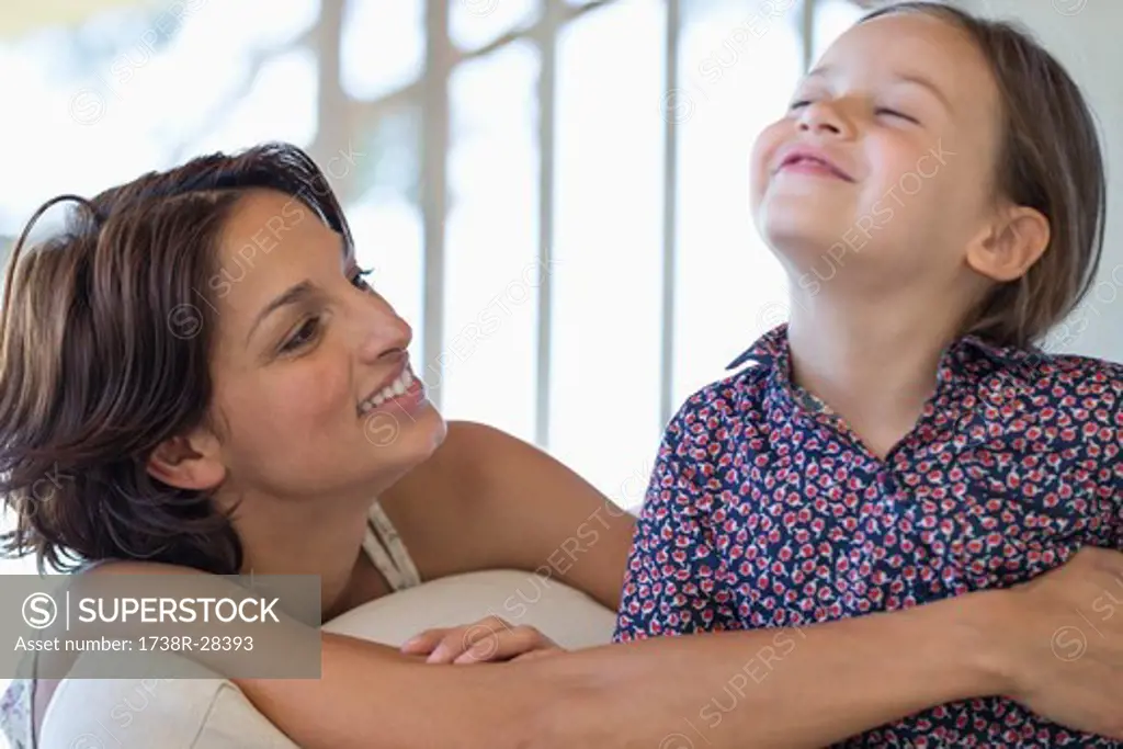 Woman smiling with her daughter at home