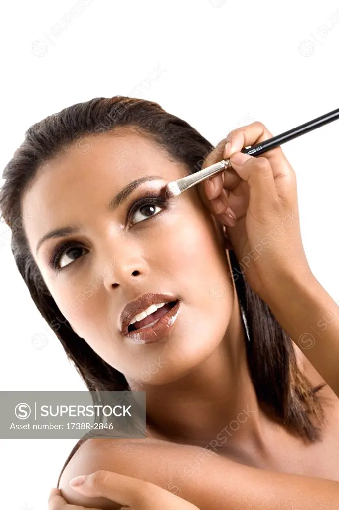 Portrait of a young woman applying eyeshadow