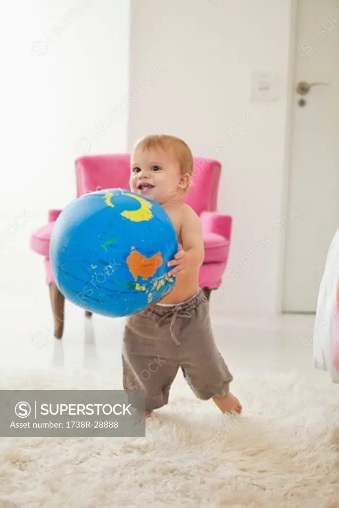 Baby boy playing with a globe ball