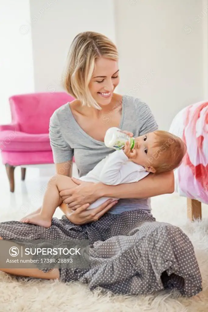 Woman feeding milk her baby with a bottle