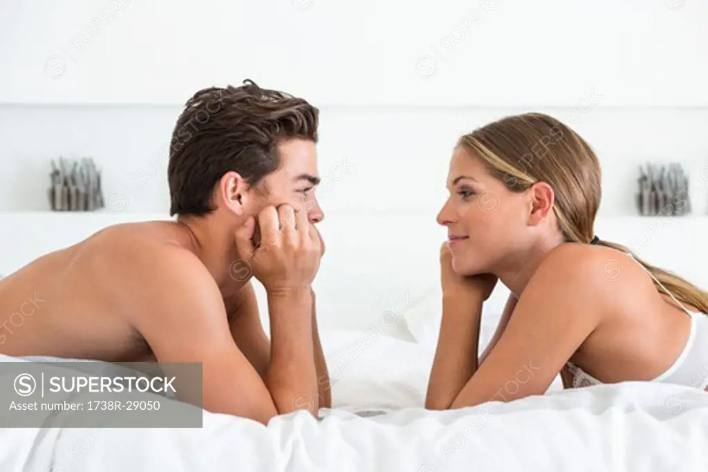 Couple lying face to face on the bed