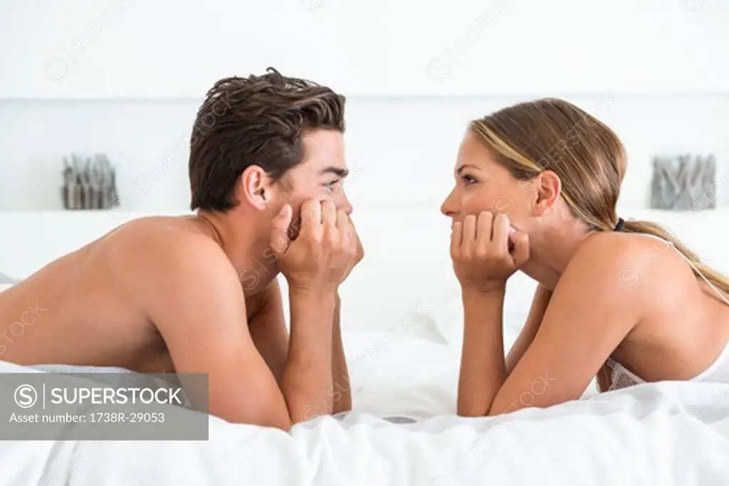 Couple lying face to face on the bed