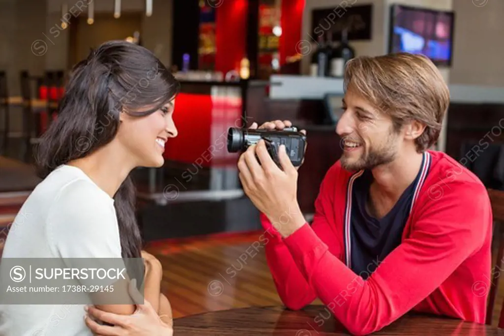 Man filming his girlfriend with a home video camera