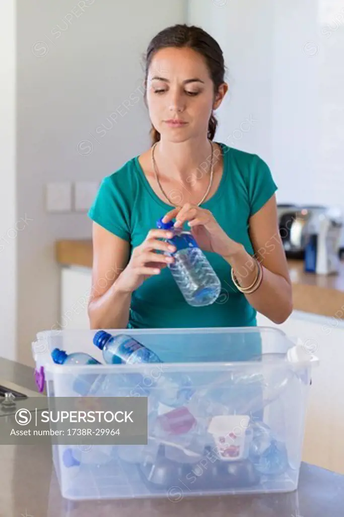 Woman putting a bottle in a recycling bin