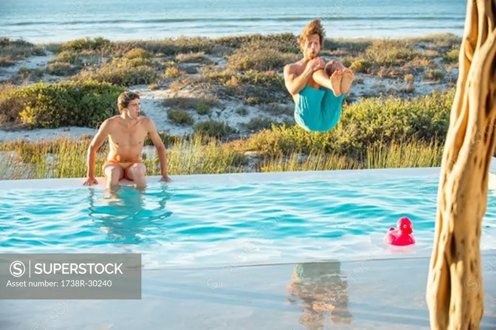 Two male friends enjoying in a swimming pool on the beach