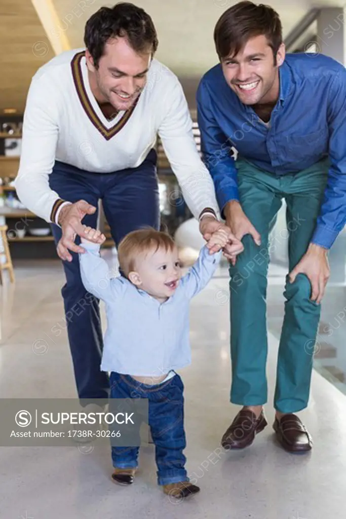 Parents helping their son to walk
